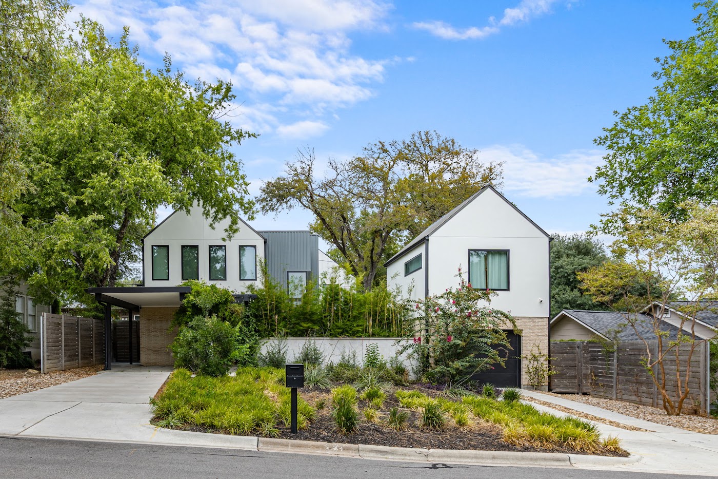 Modern Austin home at 2010 De Verne with white gabled architecture and lush landscaping, photographed by Bobby Galvan